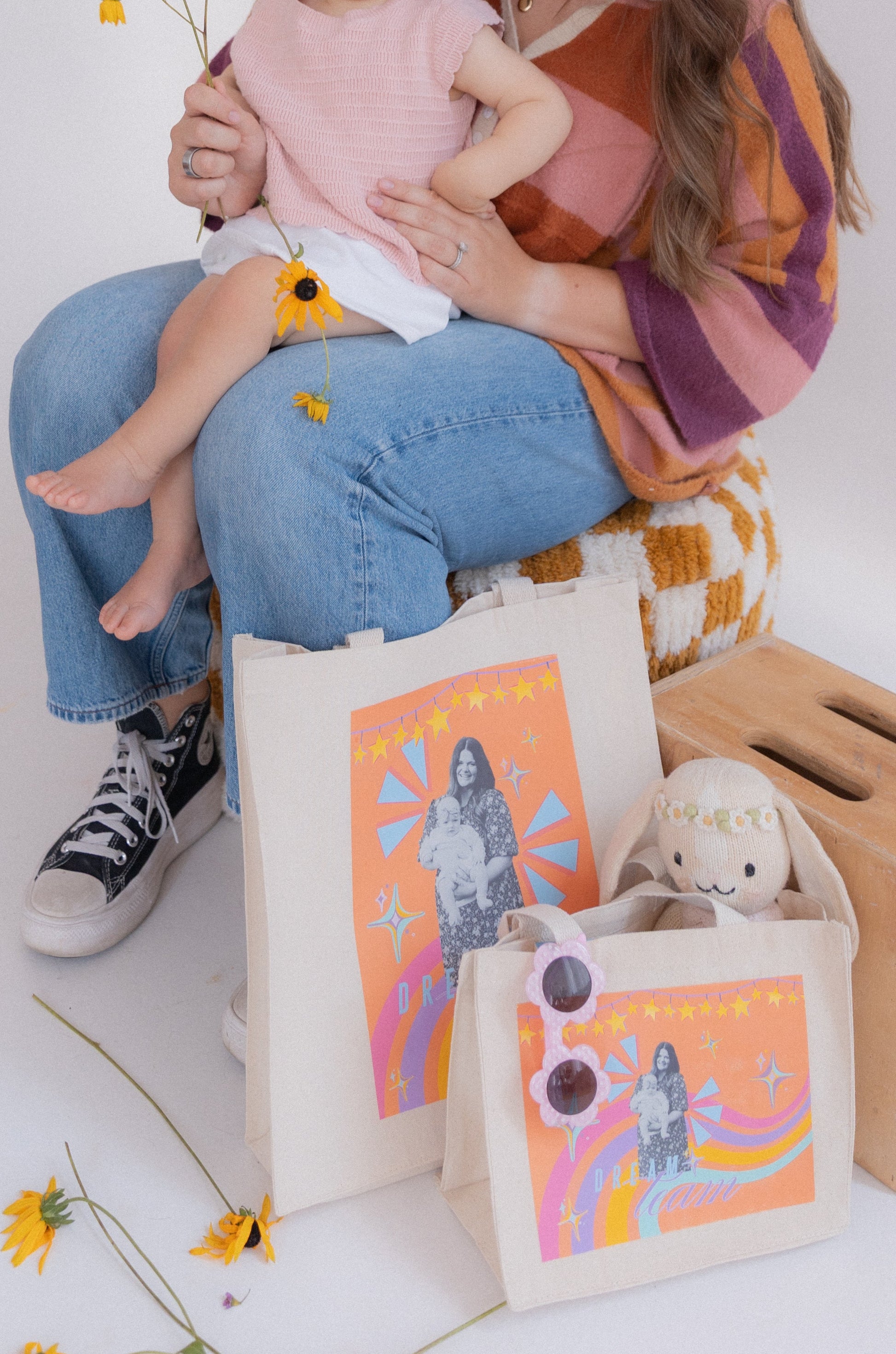 Woman holding a baby with decorative bags and a box on a white background