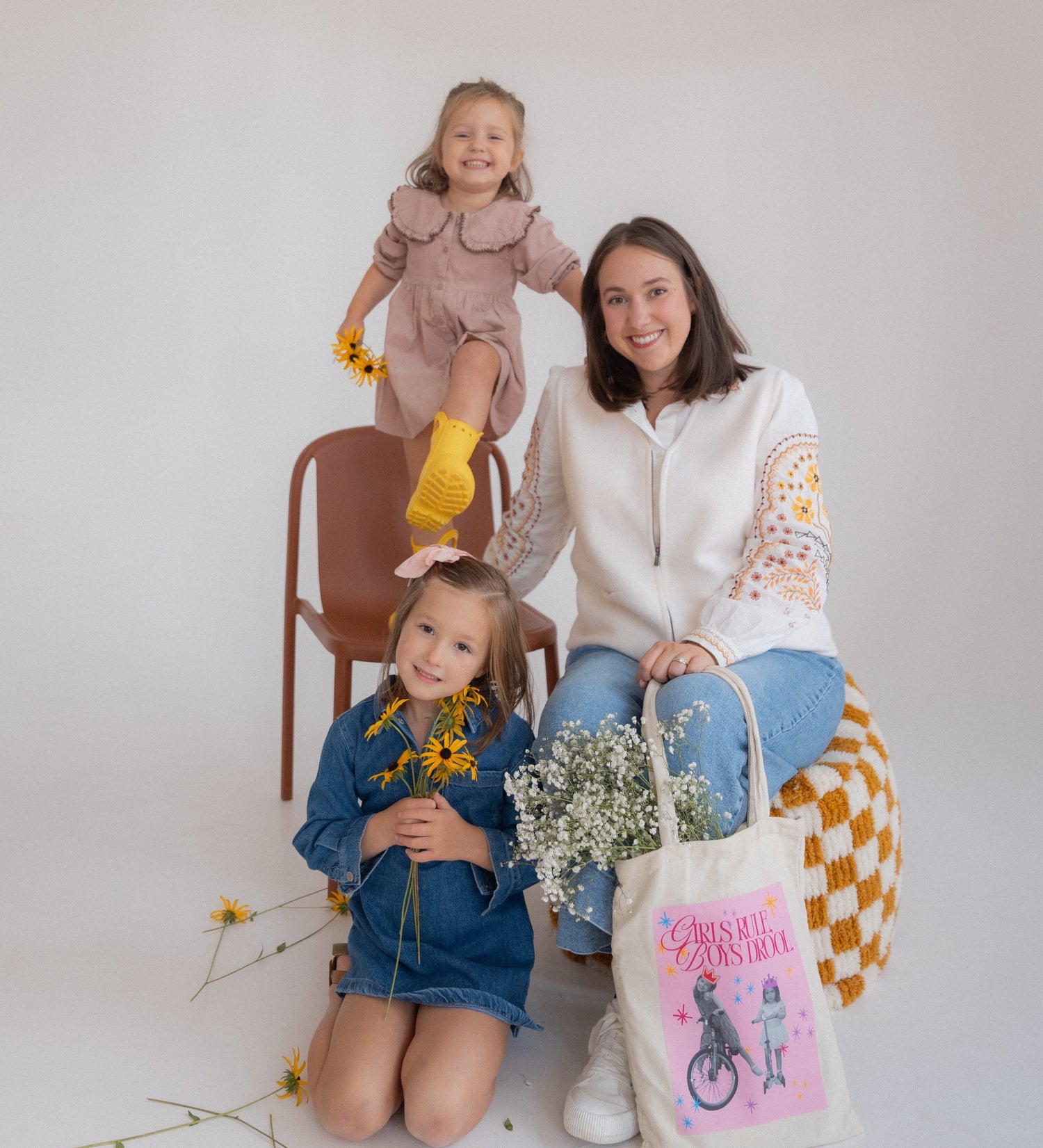 Woman and two children posing with a custom tote bag on a light background